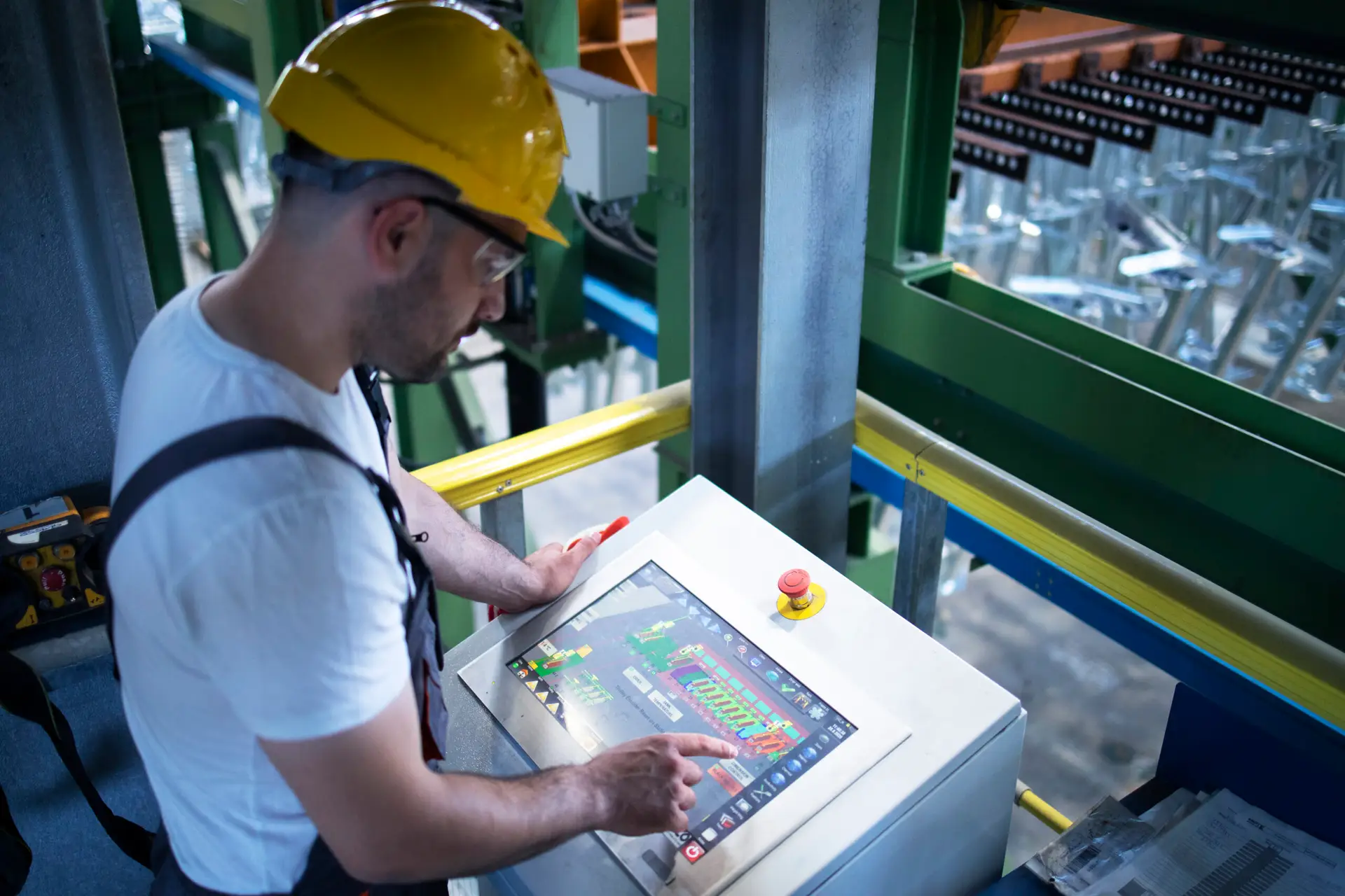 factory worker monitoring industrial machines and production remotely in control room.